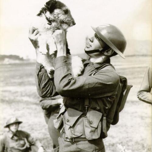 [Soldier holding up a dog during Army Day]