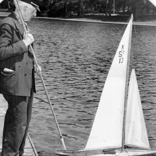 [G. C. Gallagher with a model yacht at Spreckels Lake in Golden Gate Park]