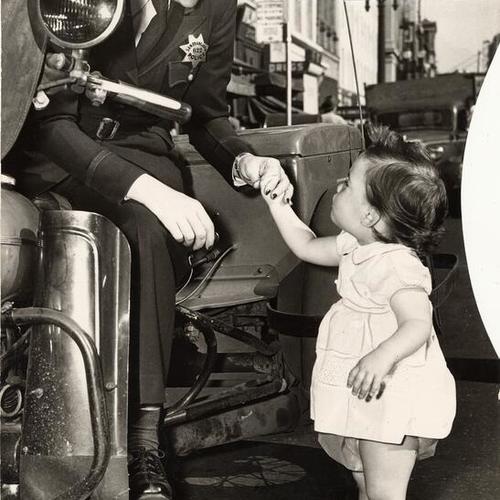 [Patrolwoman Amy Sliger helping a child]