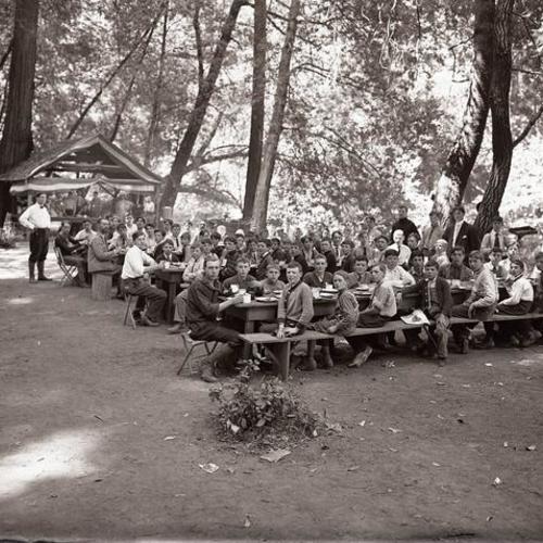 People sitting for meal outside at Camp McCoy