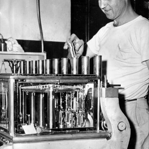 [Employee Frank Rounds adjusting a machine which rejects off-weight coins at the U. S. Mint in San Francisco]