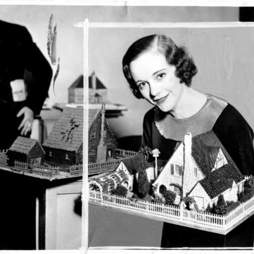 [Lillian Jackson holding up two Dream Home models for the Dream House competition]