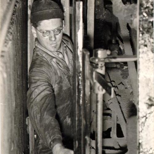 [Shop mechanic Ray Hirth demonstrating a safety feature of a streetcar]