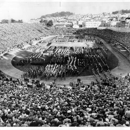 [Crowd watching marching band on field at Kezar Stadium]