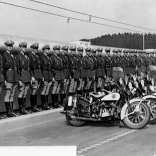 [Highway patrol officers pose with their motorcycles on Bay Bridge]