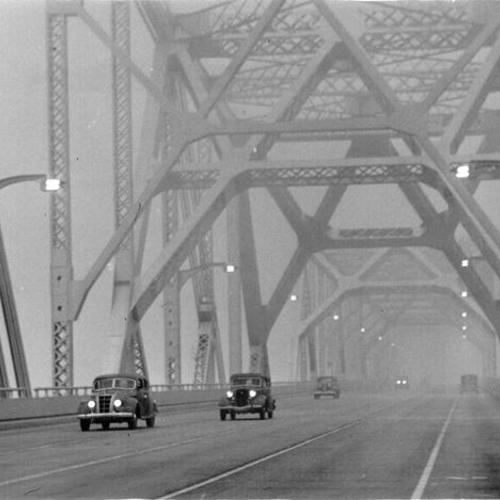 [Traffic driving through fog on the San Francisco-Oakland Bay Bridge]