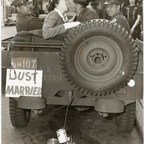 [Corporal Howard Schlereth and Miss Hatton beign whisked away in a jeep following their wedding]