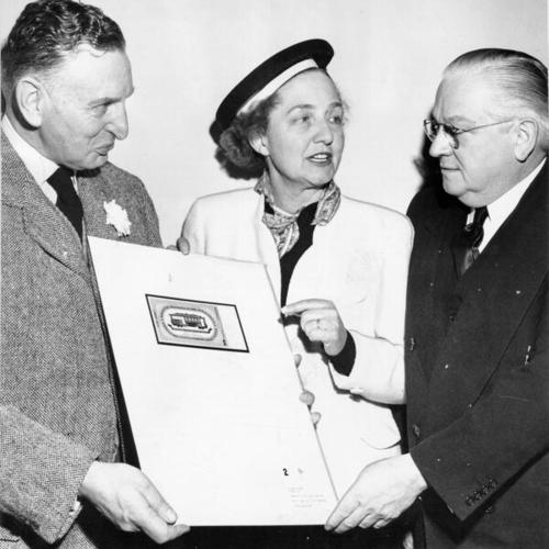 [Art Commissioner Ernest A. Born and Mrs. Hans Klussmann presenting Mayor Elmer Robinson with designs for a souvenir cable car ticket]