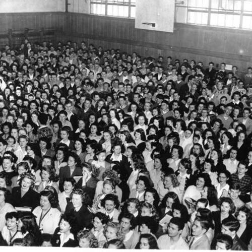 [Large group of students standing in Lowell High School's gym for the Woruth War Loan rally]