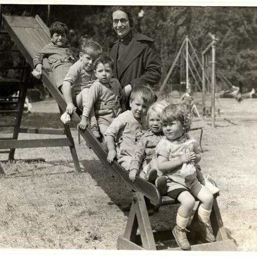 [Group of kidders on slide with Captain Ruth Grell of Salvation Army, agency of the Community Chest]