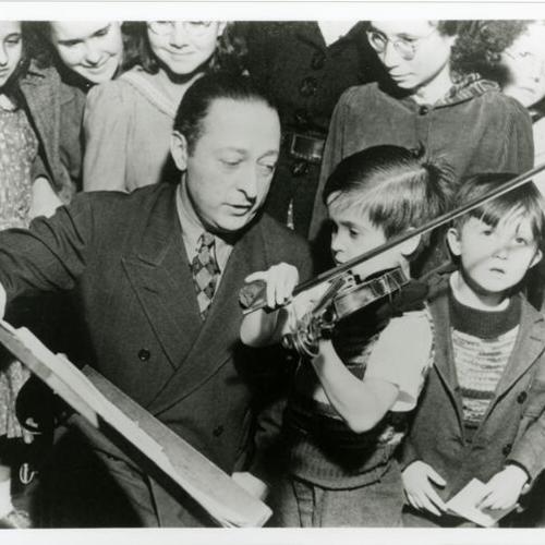 [Jascha Heifetz world famous violinist visiting the Community Music Center and students]
