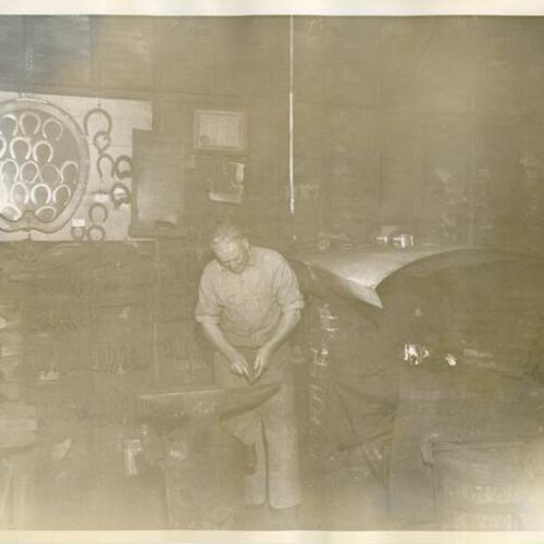 [Unidentified man working in a blacksmith shop in Visitacion Valley]