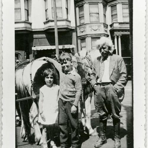 [Ruth and brother Charles standing next to horses and the "pony ride man"]