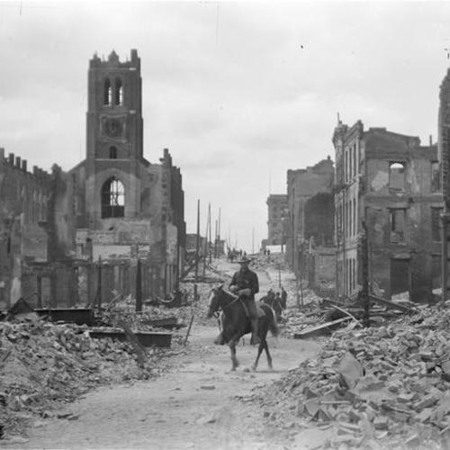 Trooper on horseback passing through building remains and rubble