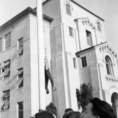 [Students protesting around an effigy hanging from flag pole outside of Balboa High School]