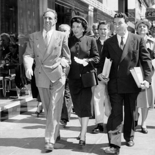 [Harry Bridges strolls down the street with Mrs. Bridges and defense attorney Vincent Hallinan after his conviction on charges of perjury and conspiracy]