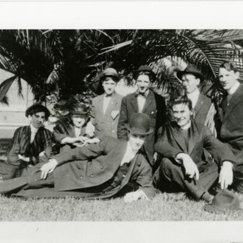 [John and friends on Dolores Street sitting under a palm tree]