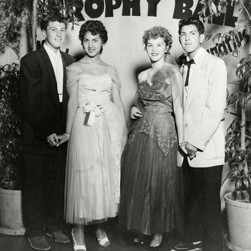 [Portrait of four young adults at a Trophy Ball at Sacred Heart School]