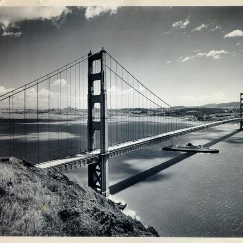 [View of the Golden Gate Bridge from the Marin County side, showing a ship passing underneath the bridge and San Francisco in the distance]