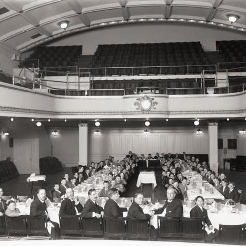 People sitting for meal in Y. M. C. A. auditorium