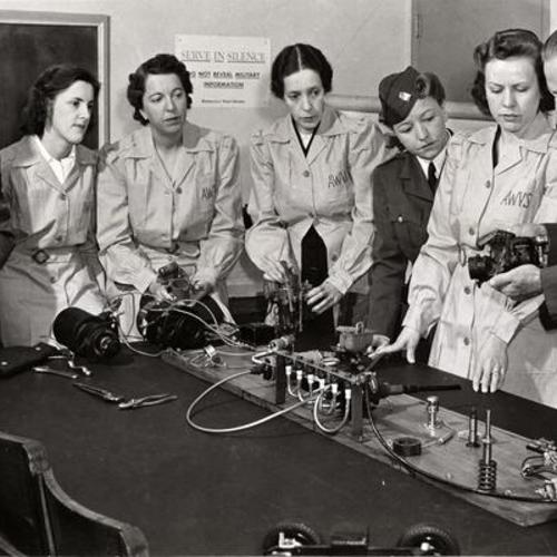 [American Women's Voluntary Services (AWVS) members attending a class on mechanics with instructor Carl Pfefferkorn]