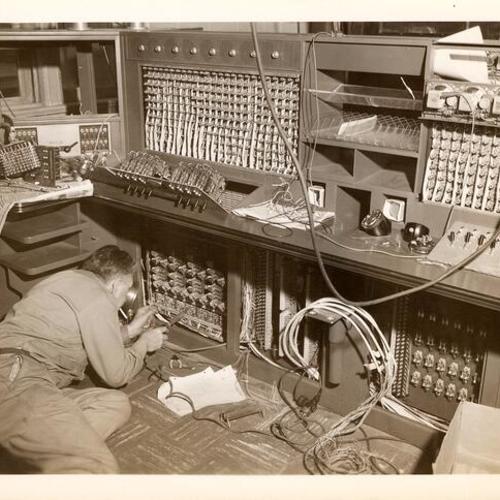 [Technician working at the new radio broadcasting console in the Communications Room in Old Hall of Justice]