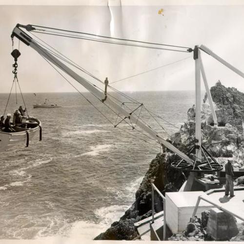 [Small boat containing U. S. Census Bureau employee Helen Leslie Mabbott and three other people being hoisted onto an island in the Farallones]
