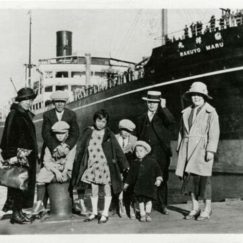 [Family standing on a dock in front of Rakuyo Maru steamship]