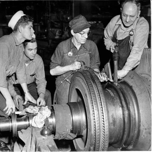 [Machinists working on a rotor blade from the aircraft carrier Badoeng Strait]