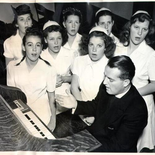 [Father Joseph Martinelli rehearsing with a section of the choir at the Home of the Good Shepherd]