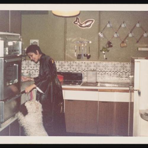 Person in kimono in kitchen with dog