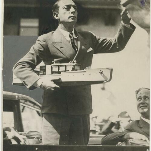 Buster Keaton in suit holding miniature ship