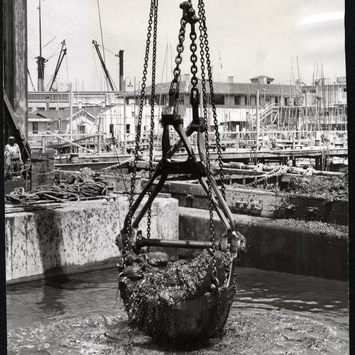 [Bucket carrying dredge from the bay at Fisherman's Wharf]
