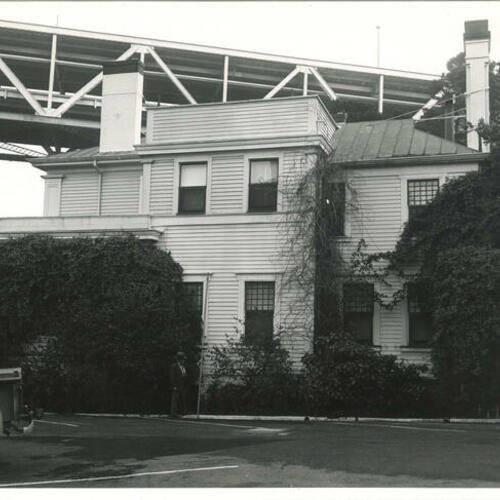 Outside view north side of Yerba Buena Island Quarters 1 with man standing in front of building