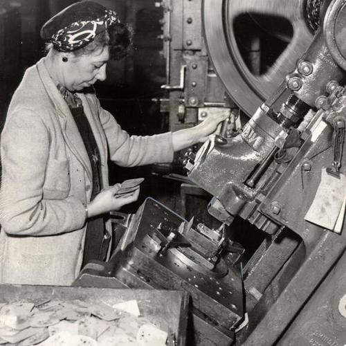 [Hilda Tinkey stamping out pieces of metal at the Bankers Utilities Company]