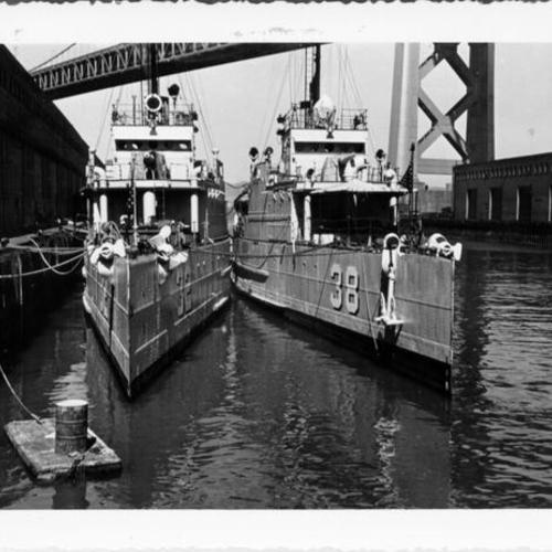 [Two ships docked at a pier near the Bay Bridge]