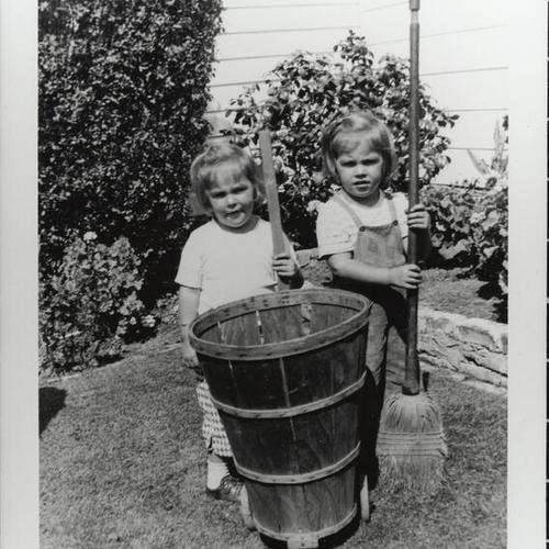 [Twin sisters are cleaning grandparent's backyard]