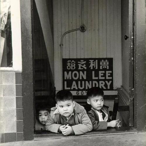 [Three young Chinese boys sitting on the stairs of the Mon Lee Laundry]