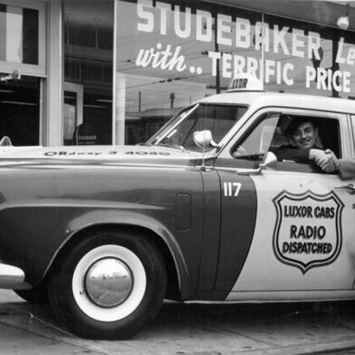 [Earl W. Patterson and L. E. Von Schultheis posing with the first Aerodynamic Studebaker Champion to be used as a taxicab in San Francisco]