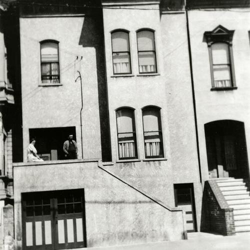 [Two people in front of doorway of house on Treat Street]