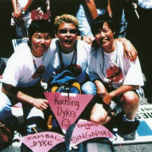 [Three women at Pride Parade holding signs]