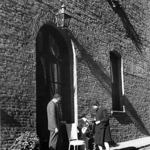 [A furniture dealer and a decorator examining an antique chair in Jackson Square]
