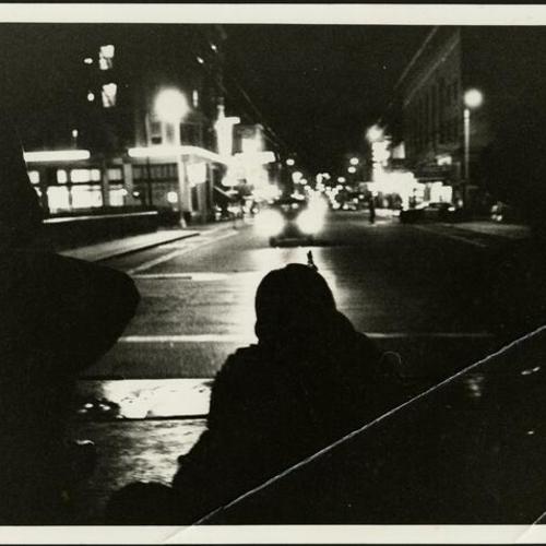 [Officer aiming a gun at night during the 1966 Bayview-Hunters Point riots]