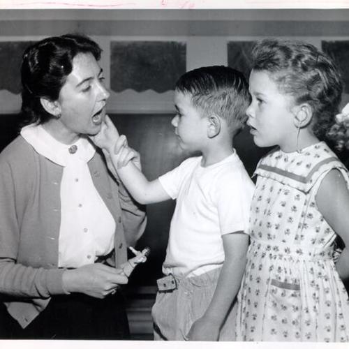 [Teacher with two children at Gough School for the Deaf, 1945 Washington Street]