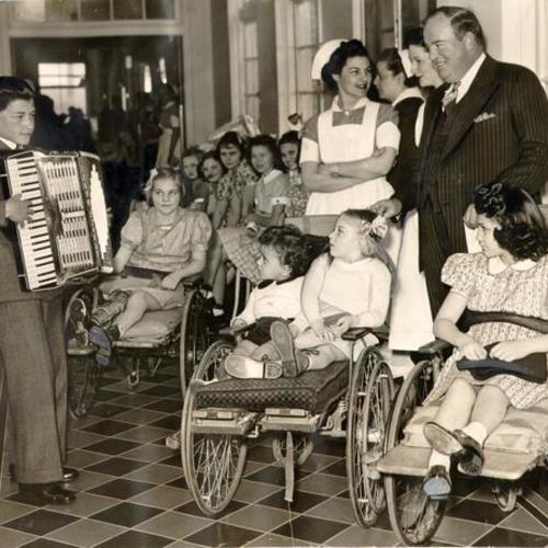 [Accordionist Frank Borg entertaining patients at the Shriners' Hospital for Crippled Children]