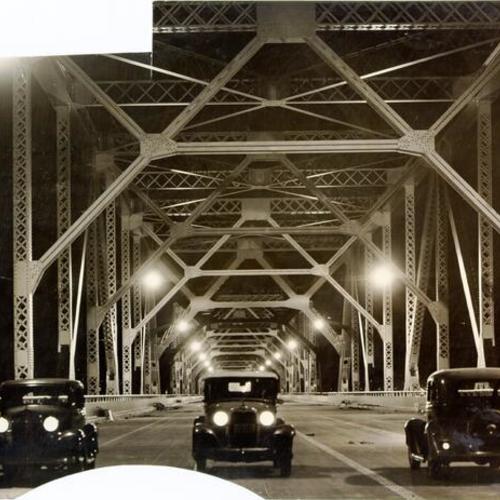 [Night view of motorists passing through lower deck of San Francisco-Oakland Bay Bridge cantilever highway span]