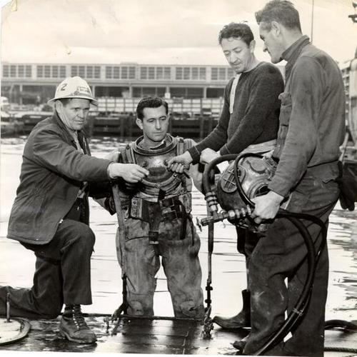 [Milton Delaney checking helmet before it is placed on diver]