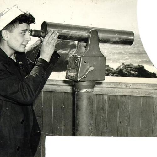 [Earl A. Edwards squinting through a telescope to view Seal Rocks]