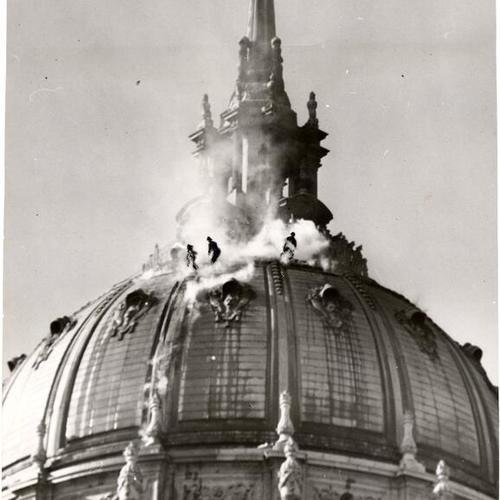 [Firefighters battling a fire on top of City Hall's dome]