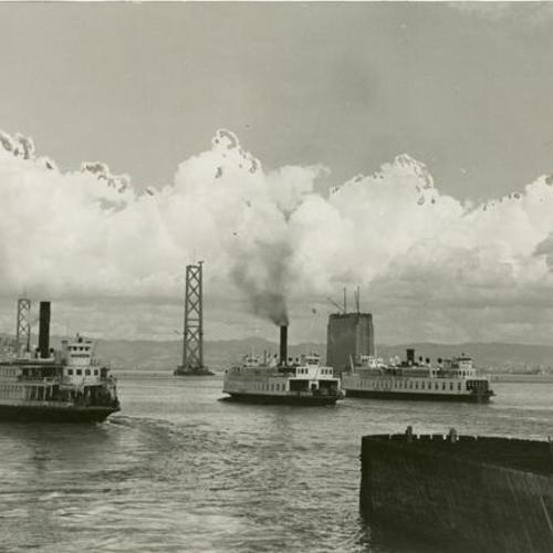 [Ferryboats approaching dock with a view of the Bay Bridge towers]